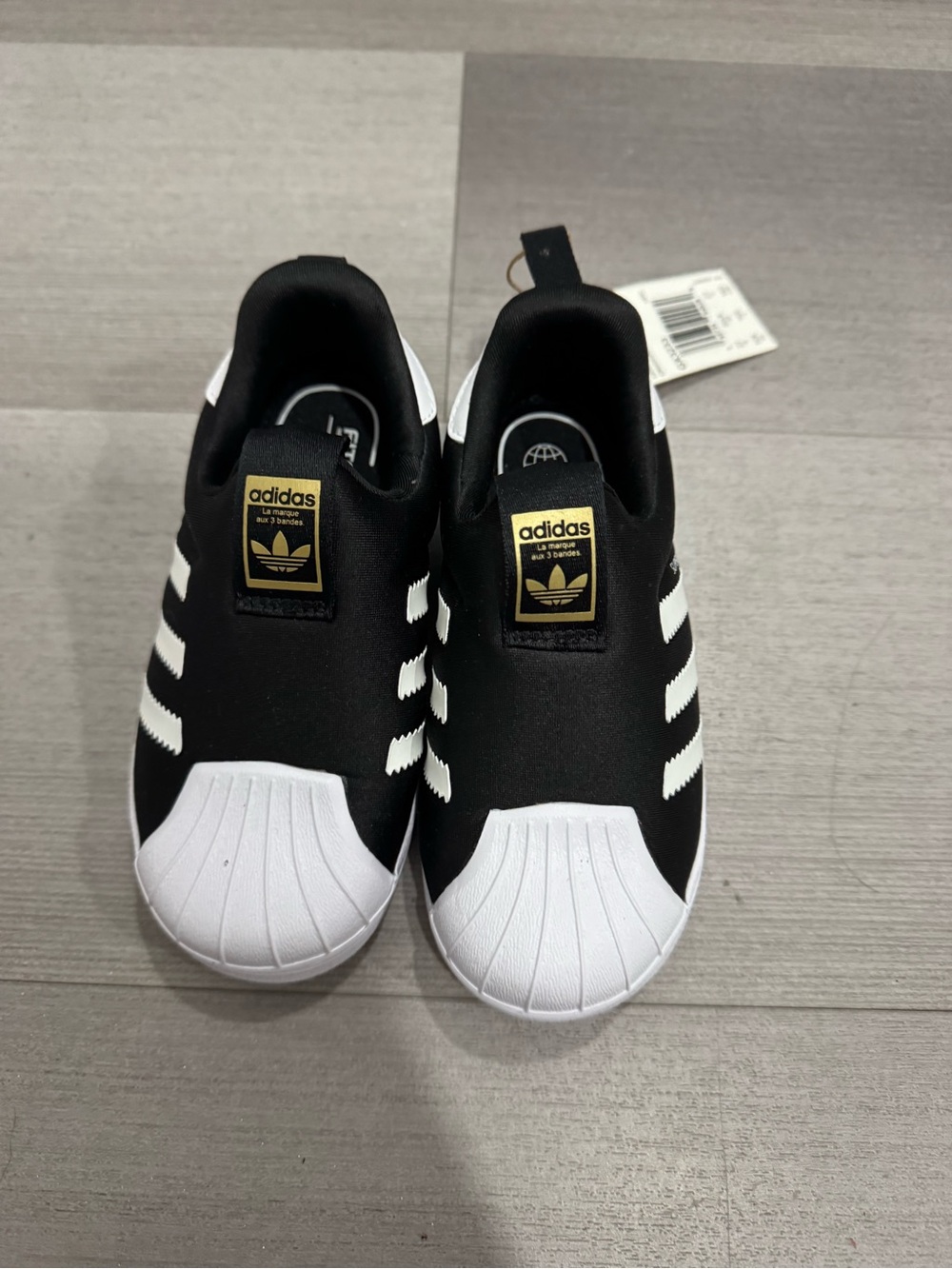 adidas Kids Black & White Slip-On Shell Toe Sneakers with Gold Logo